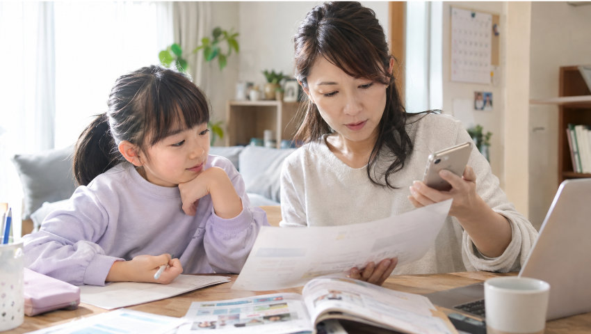 子どもと書類を見る保護者